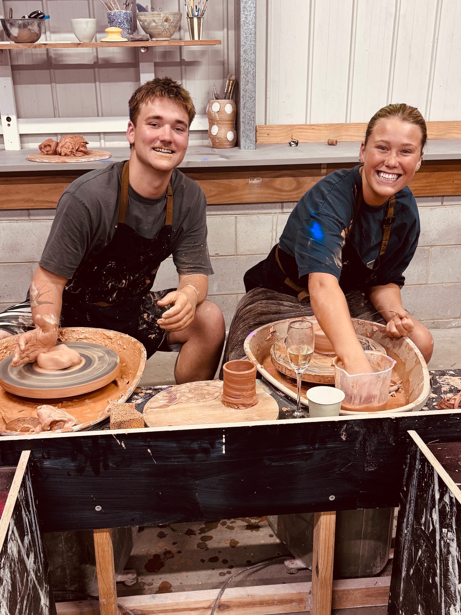 Jack and Issy laughing at their wheels inside The Throwing Shed