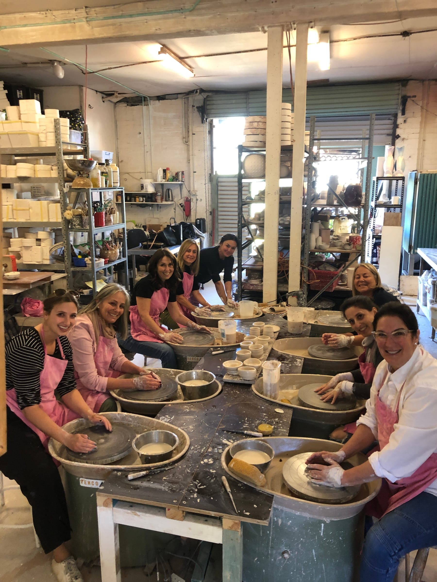 A full Thursday class smiling from behind a line of wheels